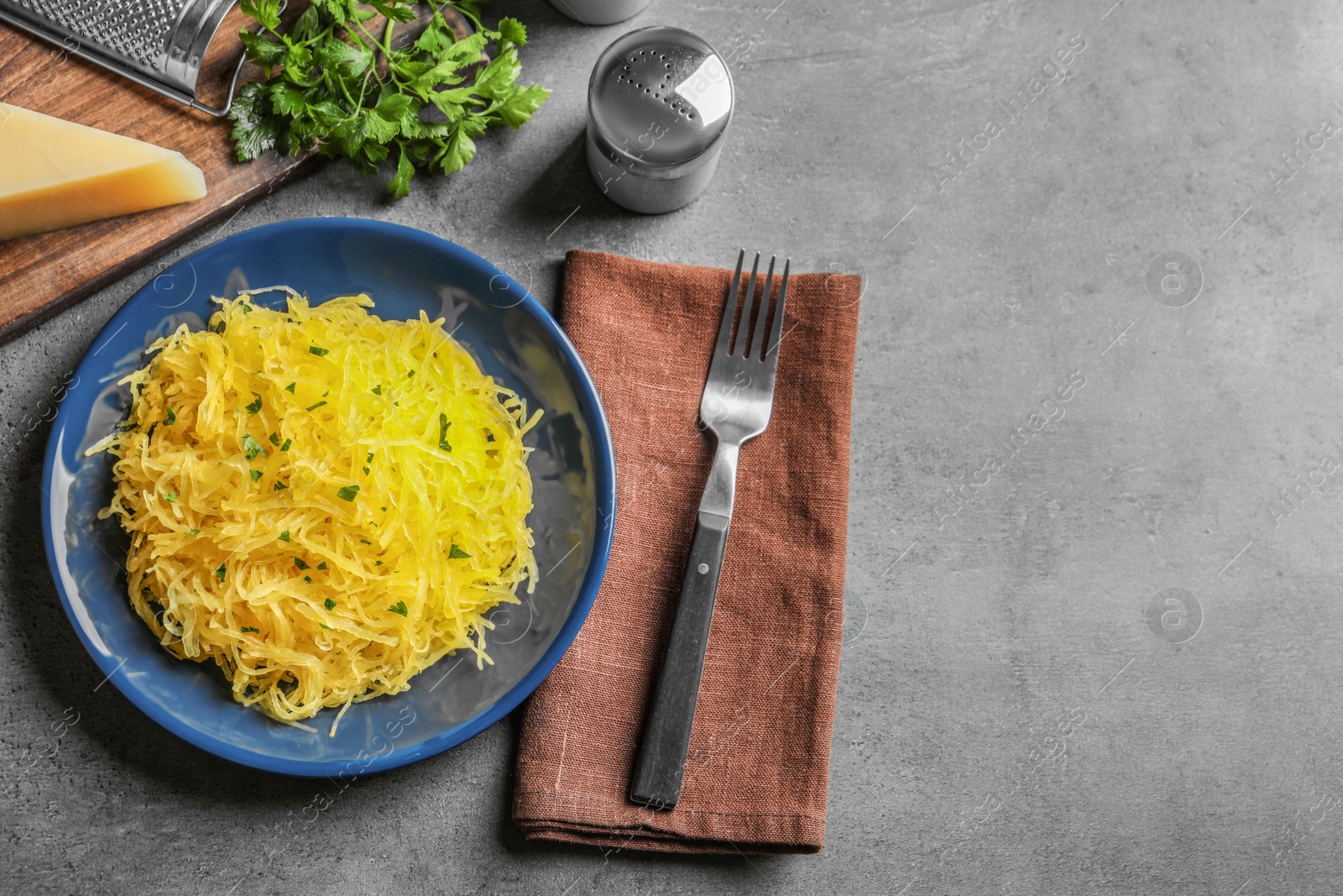 Photo of Flat lay composition with cooked spaghetti squash and space for text on grey table
