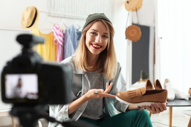 Photo of Fashion blogger recording video on camera at home