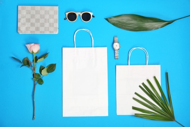 Photo of Stylish flat lay composition with shopping bags on color background