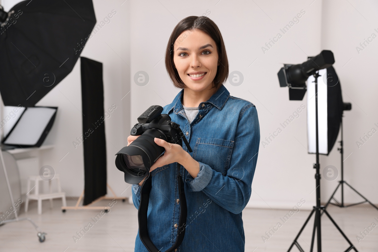 Photo of Professional photographer with camera in modern photo studio