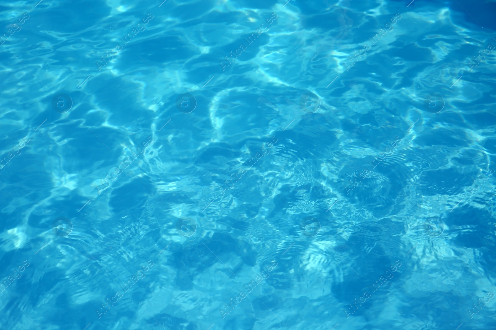 Photo of Texture of blue water in swimming pool as background, closeup