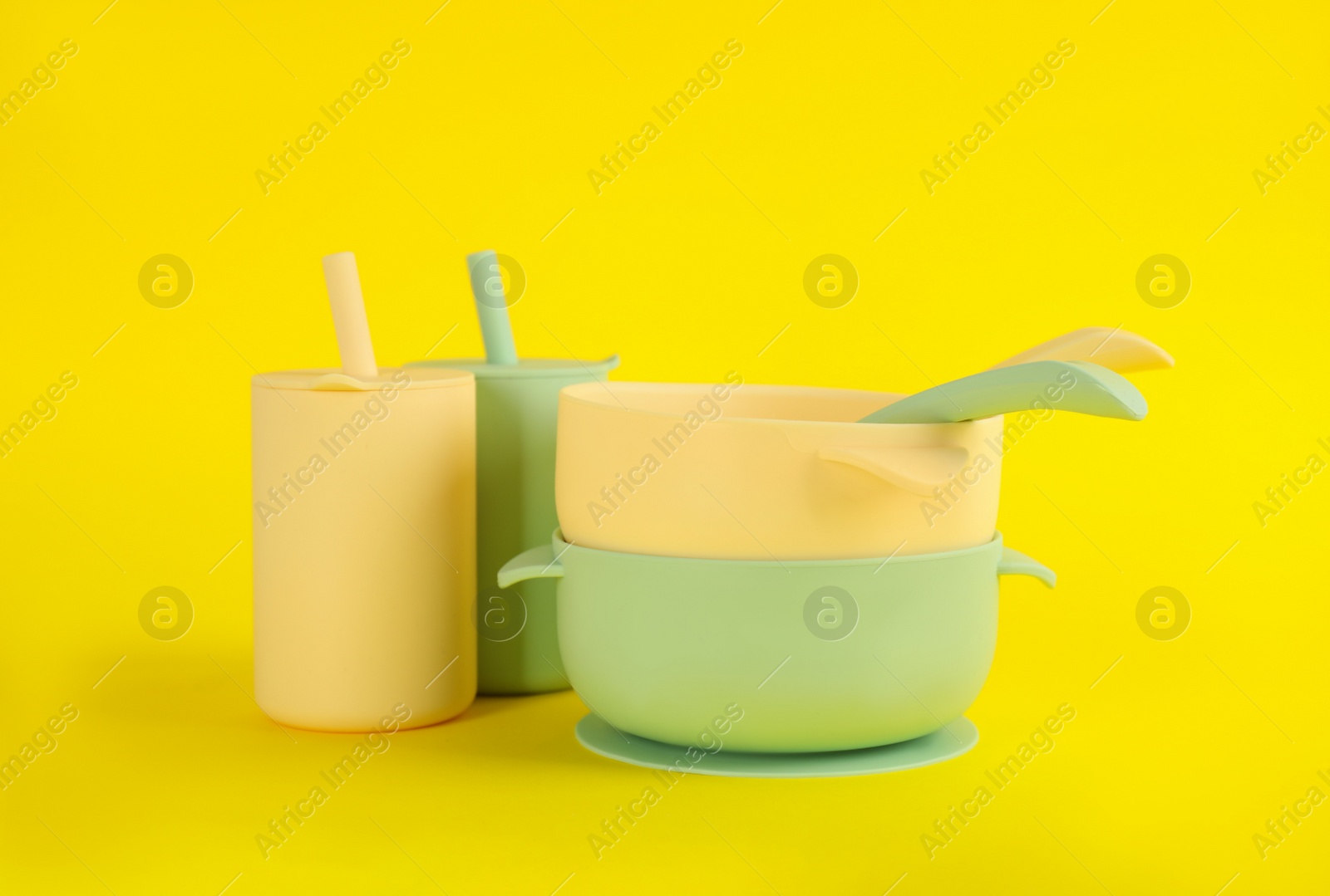 Photo of Set of plastic dishware on yellow background. Serving baby food