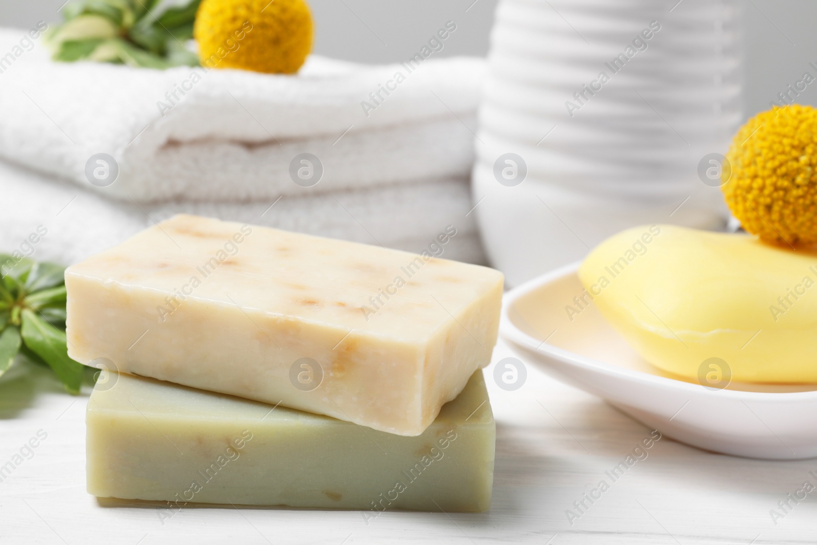 Photo of Soap bars on white wooden table, closeup
