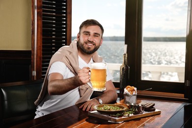 Photo of Man with glass of tasty beer in pub