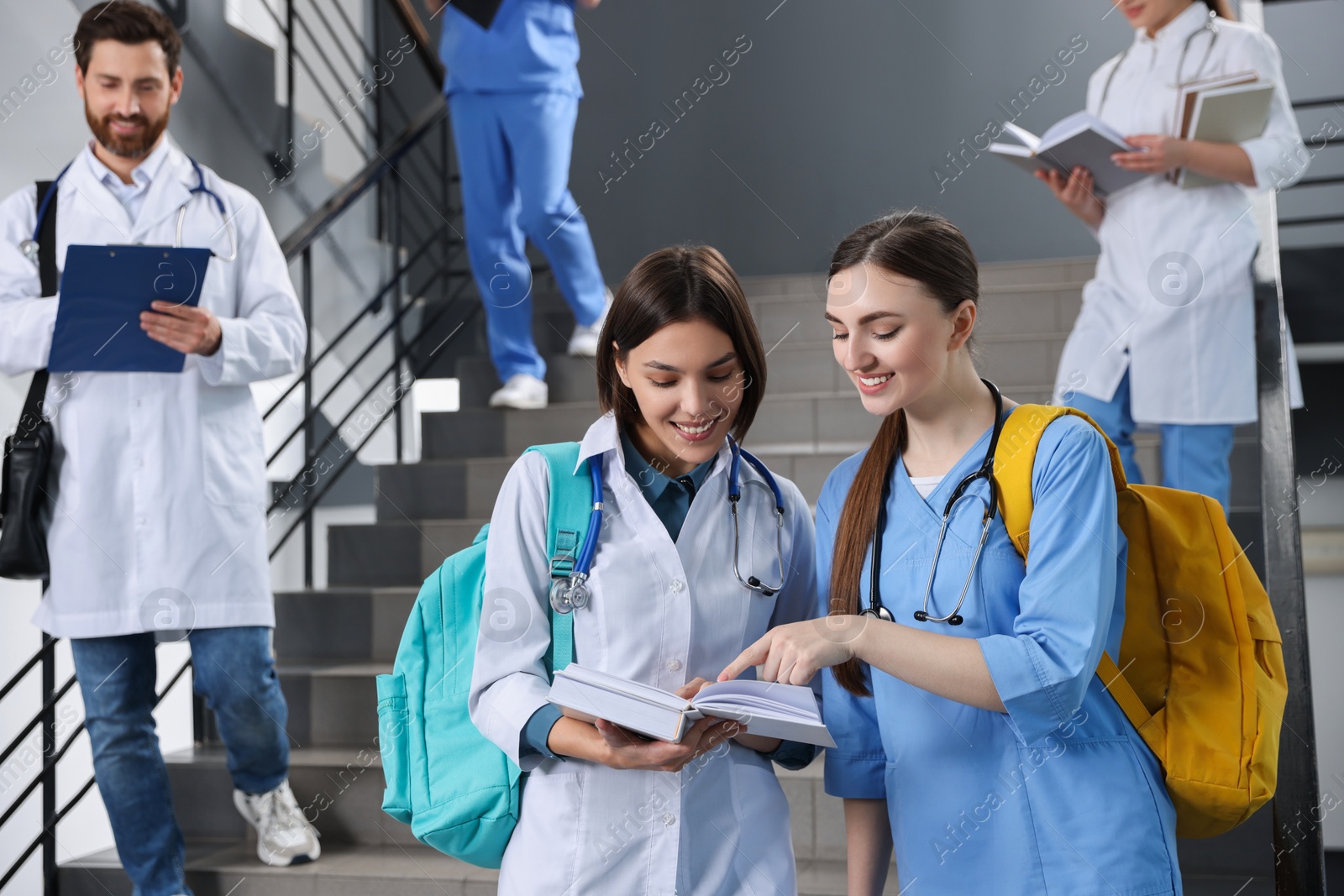 Photo of Medical students wearing uniforms on staircase in college, space for text