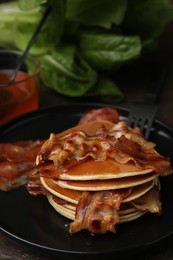 Delicious pancakes with fried bacon served on wooden table, closeup