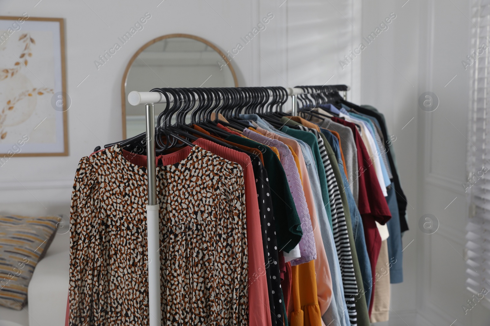 Photo of Rack with stylish clothes indoors. Fast fashion