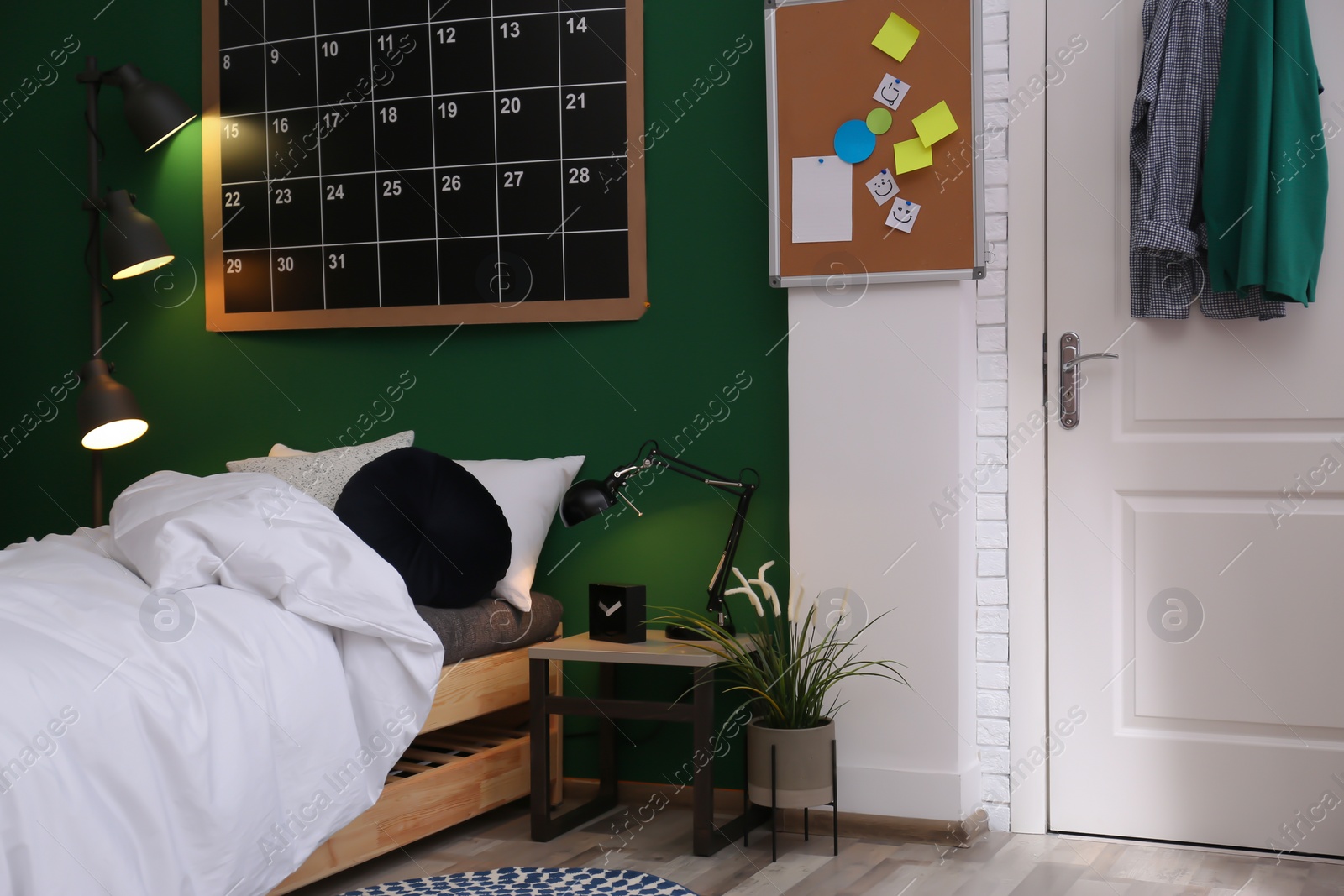 Photo of Modern teenager room interior with comfortable bed against green wall