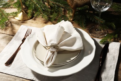 Photo of Stylish table setting with white fabric napkin, beautiful decorative ring and festive decor on wooden background