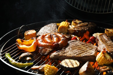 Photo of Assorted delicious meat and vegetables on barbecue grill