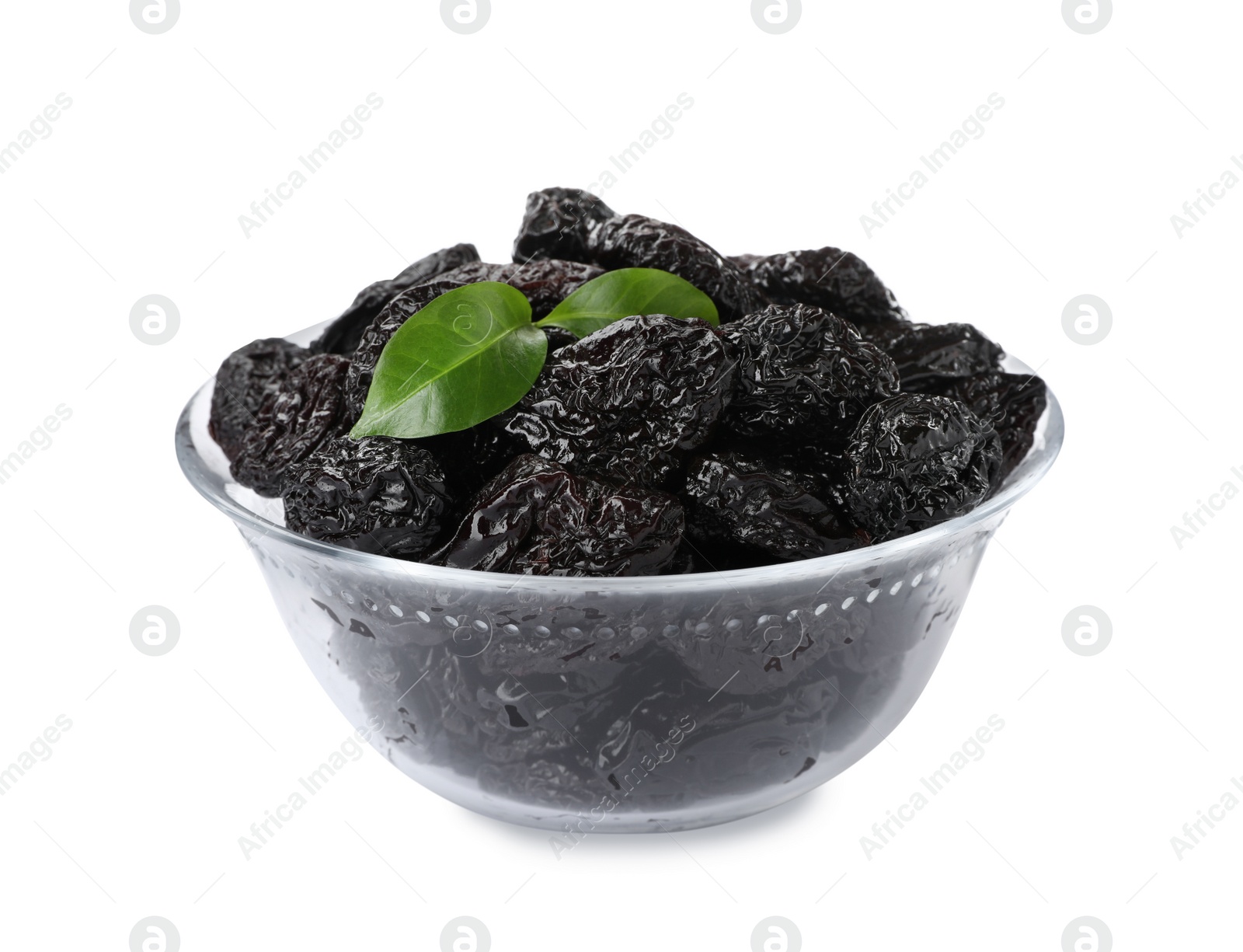 Photo of Bowl with sweet dried prunes and green leaves isolated on white