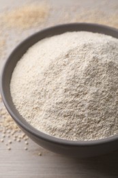 Photo of Ceramic bowl with quinoa flour and seeds on wooden table