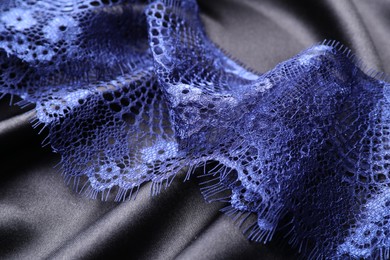 Beautiful blue lace on black fabric, closeup