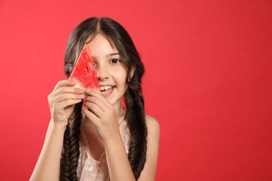Photo of Cute little girl with watermelon on red background. Space for text