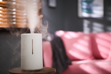 Modern air humidifier on table indoors. Space for text