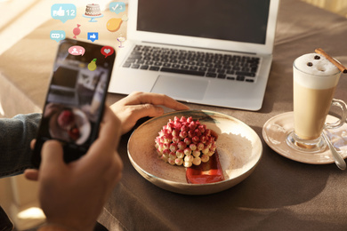 Young blogger taking picture of dessert at table in cafe, closeup