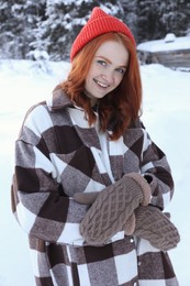 Photo of Portrait of beautiful young woman on snowy day outdoors. Winter vacation
