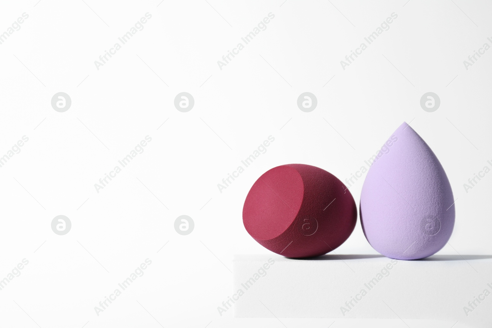 Photo of Stylish presentation of makeup sponges on white background, space for text