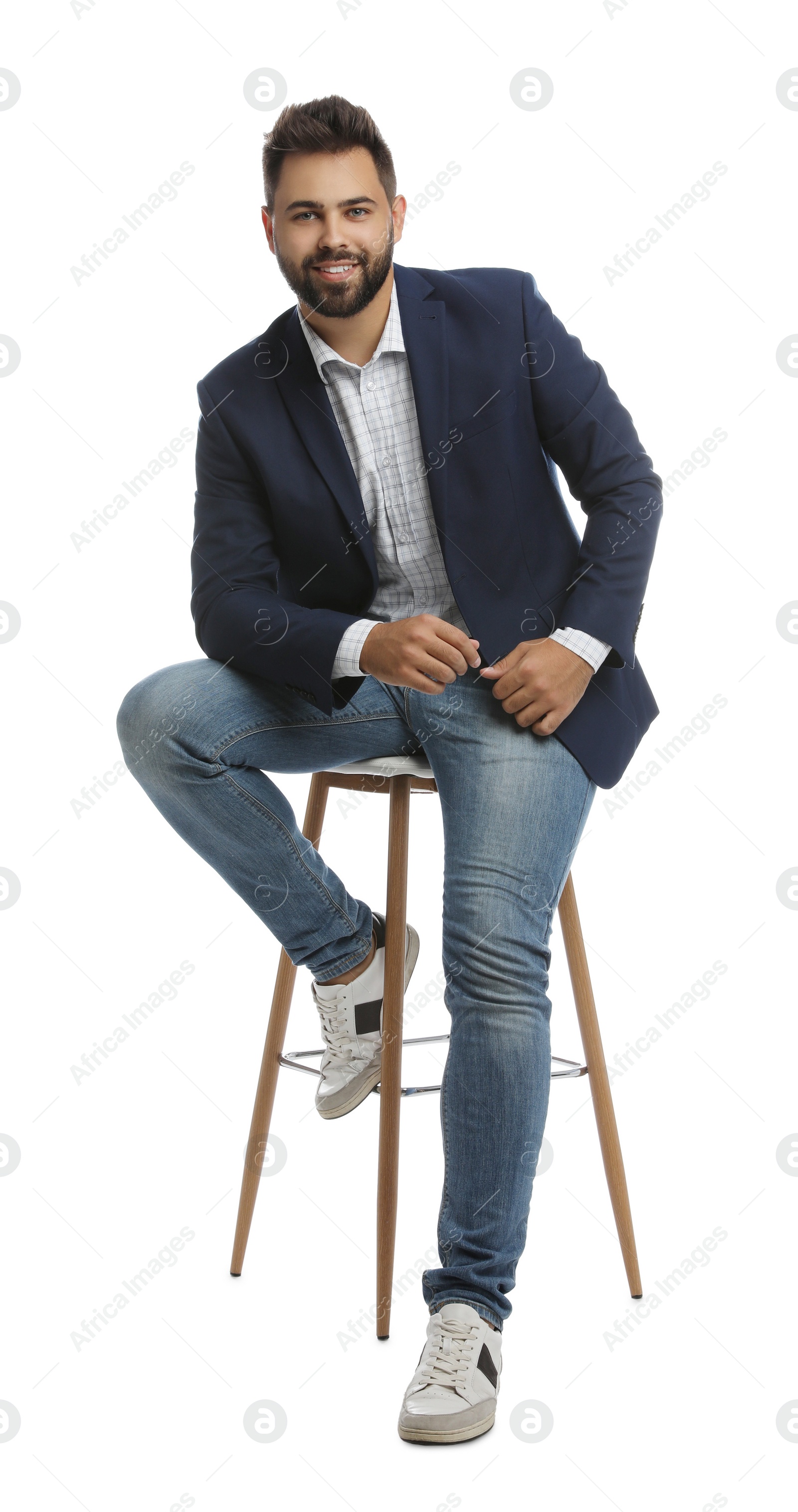 Photo of Handsome young man sitting on stool against white background