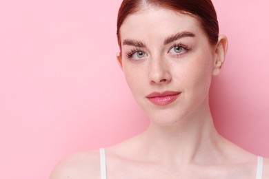 Portrait of beautiful woman on pink background, closeup