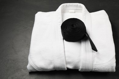 Photo of Black karate belt and white kimono on gray background