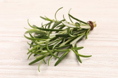 Photo of Fresh green rosemary on white wooden table, closeup