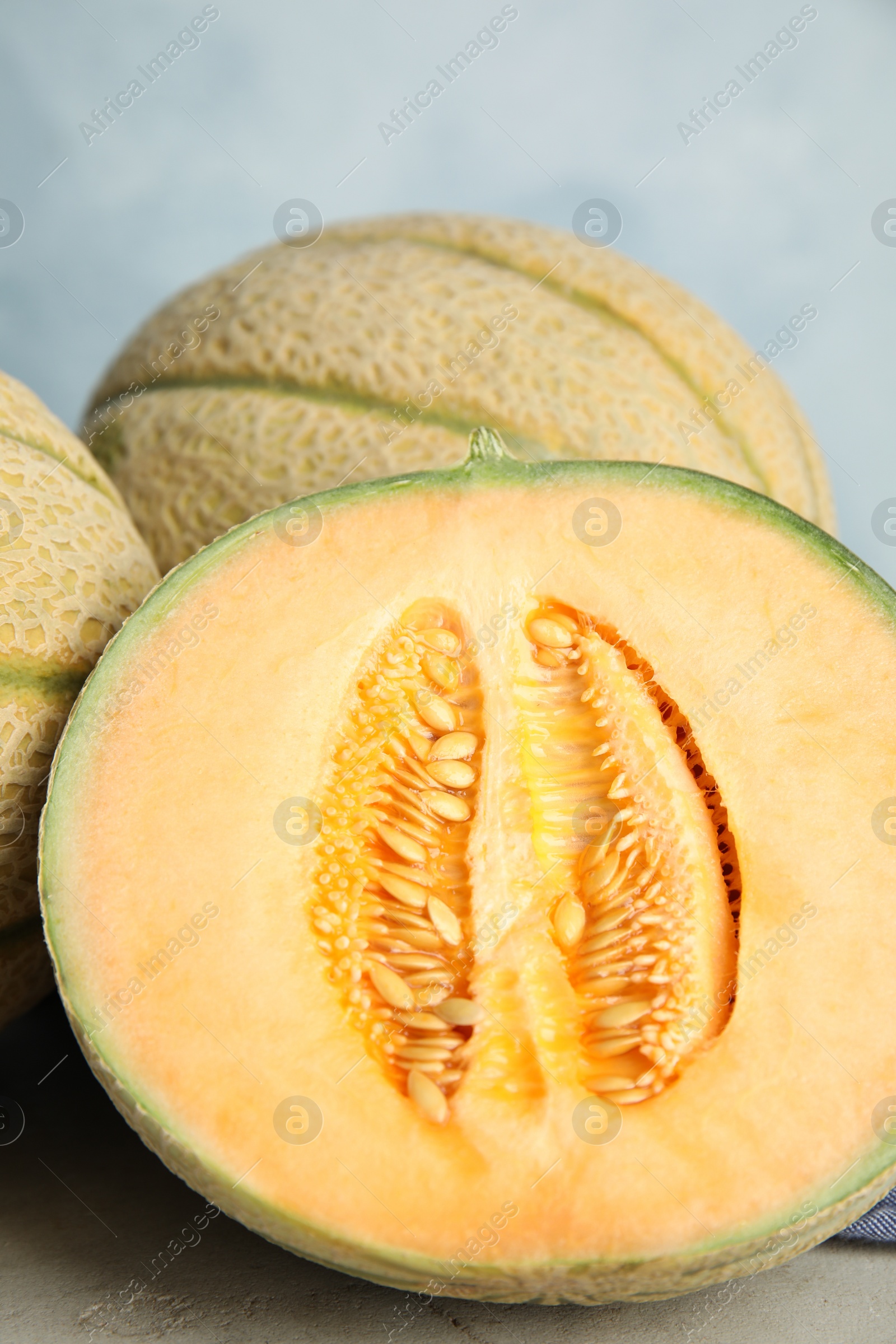 Photo of Tasty fresh melons on light grey table, closeup