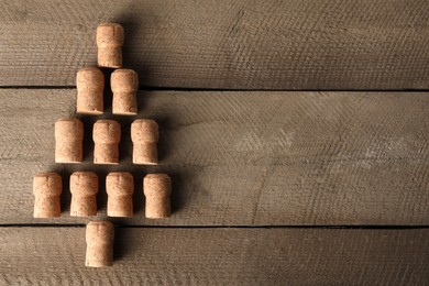 Christmas tree made of sparkling wine corks on wooden table, top view. Space for text