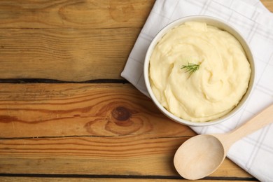 Photo of Freshly cooked homemade mashed potatoes, spoon and napkin on wooden table, flat lay. Space for text