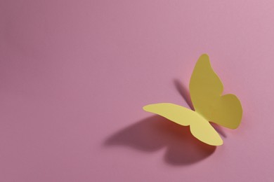 Yellow paper butterfly on pink background. Space for text