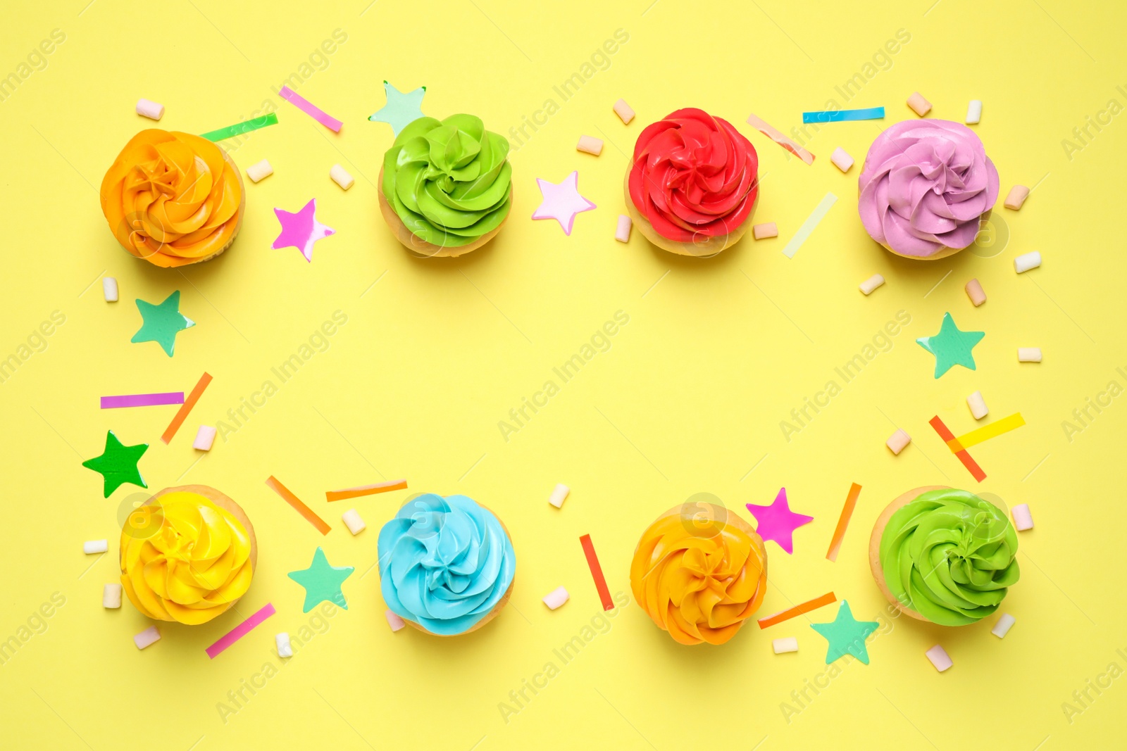 Photo of Colorful birthday cupcakes on yellow background, flat lay. Space for text