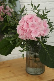 Beautiful pink hortensia flowers in vase on dressing table indoors