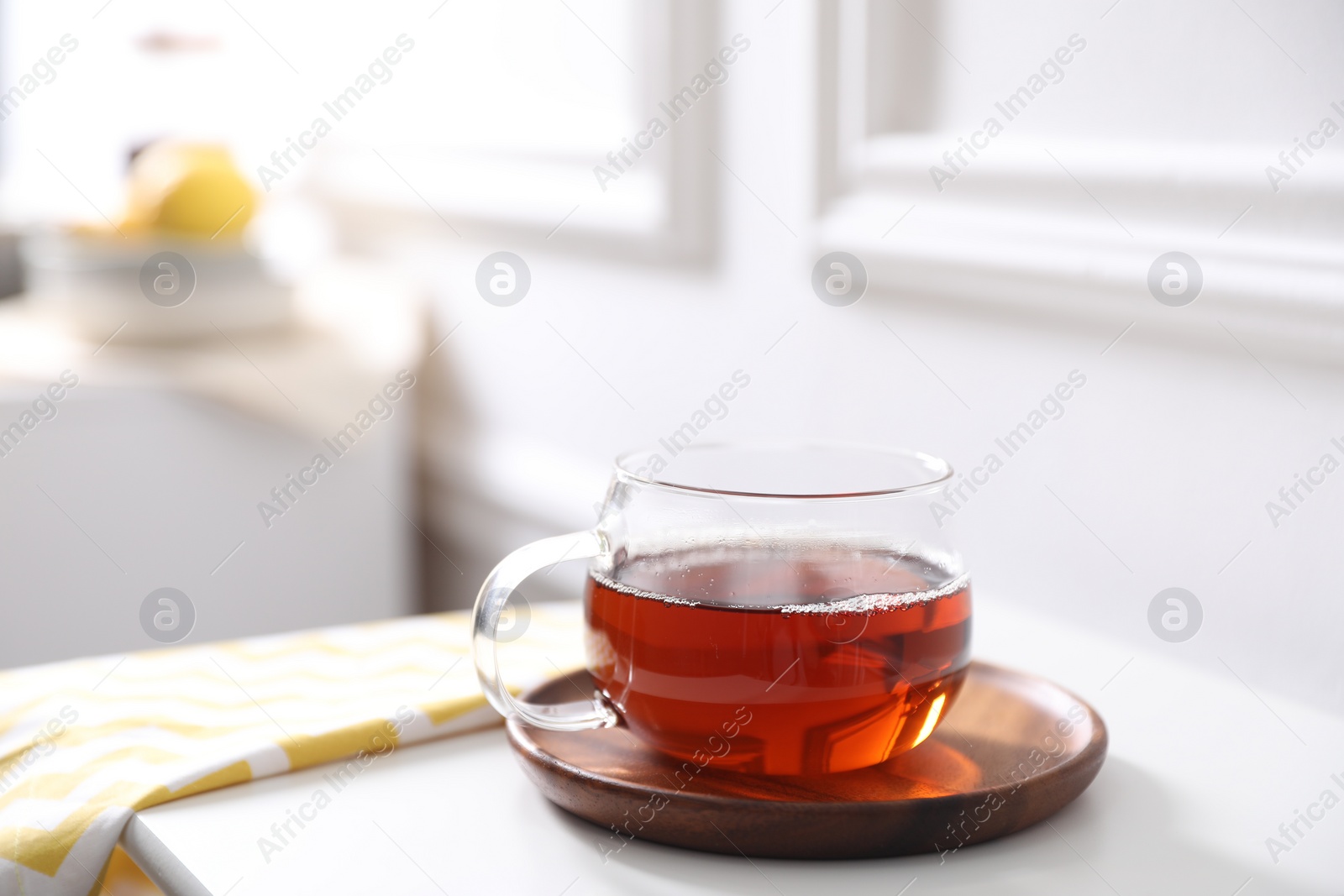 Photo of Tasty hot tea in cup on white table, closeup