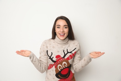Photo of Young woman in Christmas sweater on white background