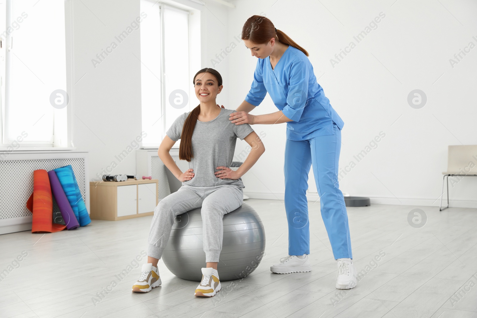 Photo of Professional physiotherapist working with female patient in rehabilitation center