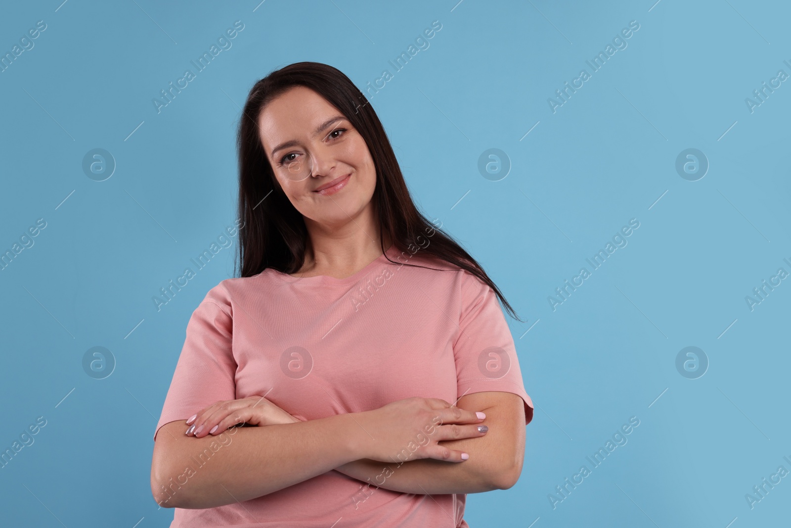 Photo of Beautiful overweight woman with charming smile on turquoise background. Space for text