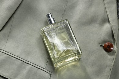 Luxury men's perfume in bottle on grey jacket, top view