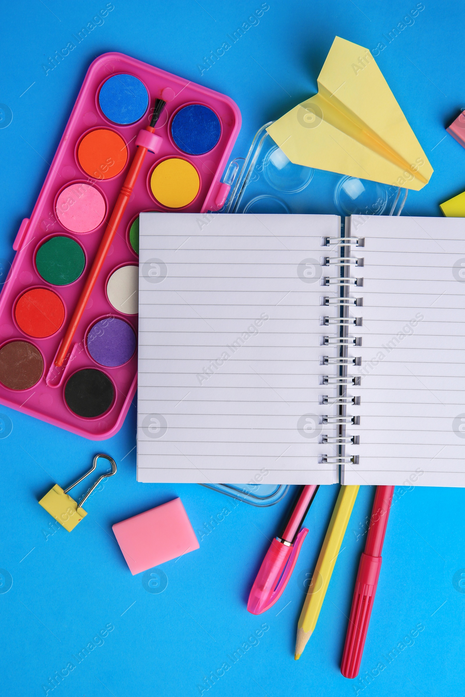 Photo of Flat lay composition with blank notebook and other school stationery on light blue background, space for text. Back to school