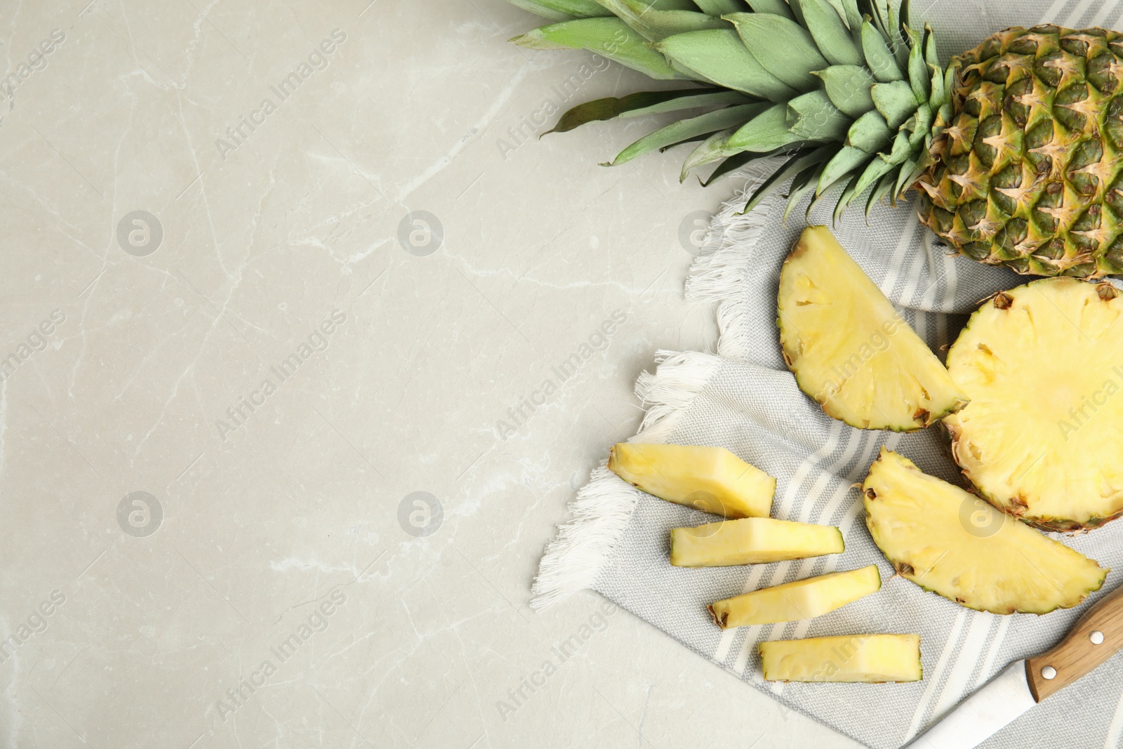 Photo of Slices of fresh pineapple on light grey marble table, flat lay. Space for text