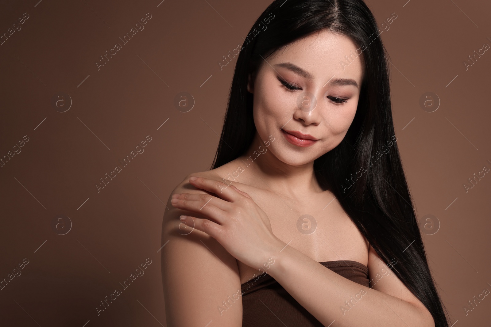 Photo of Portrait of beautiful woman on brown background