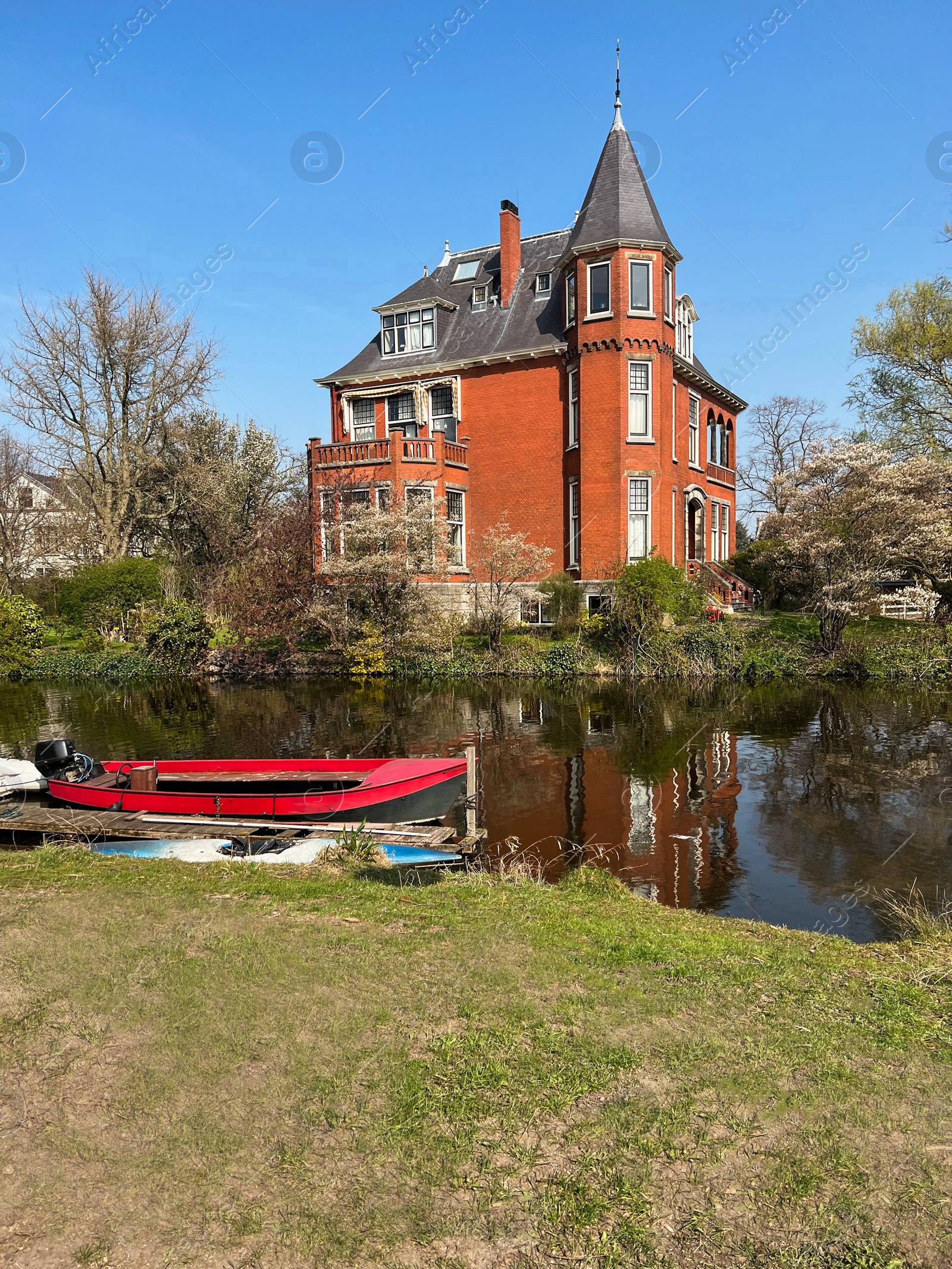 Photo of Beautiful city canal with moored boat on sunny spring day