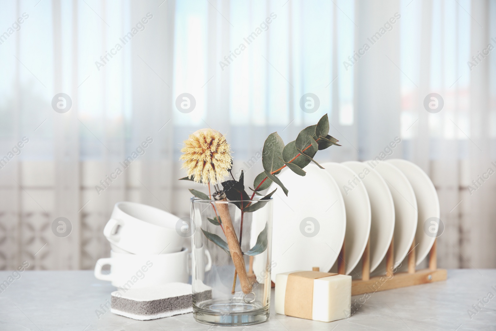 Photo of Cleaning supplies for dish washing on grey marble table indoors