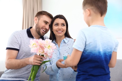 Father and son congratulating mom at home. Happy Mother's Day