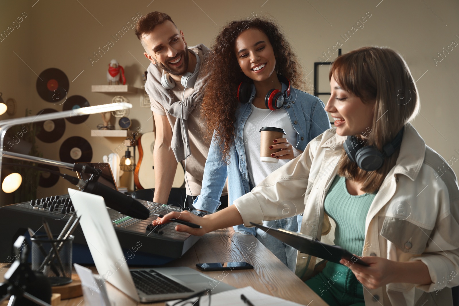 Photo of People working in modern radio studio with professional equipment