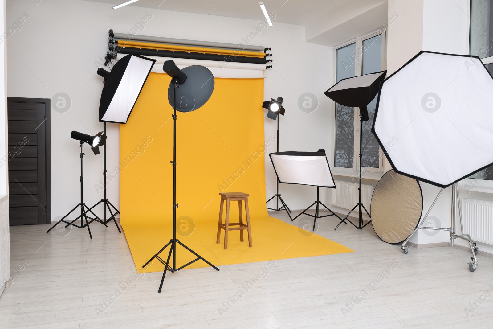 Photo of Interior of modern photo studio with bar stool and professional lighting equipment