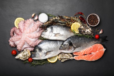 Flat lay composition with fresh raw dorado fish and different seafood on black table
