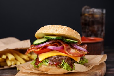 Tasty burger with bacon, vegetables and patty on wooden table, closeup