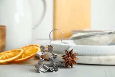 Photo of Cookie cutters, anise and crockery on white table, closeup