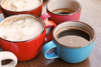 Cups of fresh aromatic coffee on wooden table