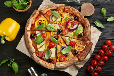 Photo of Flat lay composition with vegetable pizza on black wooden table